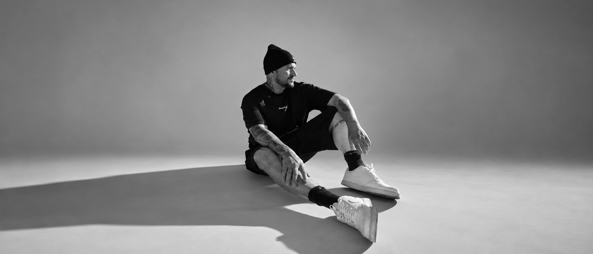 IKNOWMARK seated in a black and white studio portrait